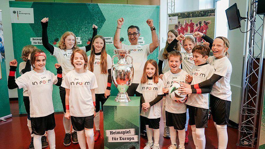 Bundesminister Cem Özdemir, 11 Kinder in Fußballkleidung, EM-Pokal