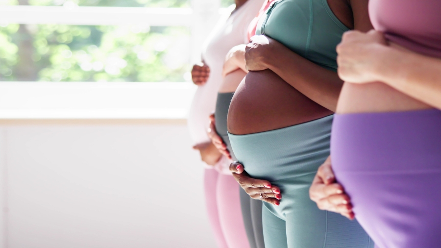 Drei Schwangere in einer Reihe, man sieht hauptsächlich die Bäuche