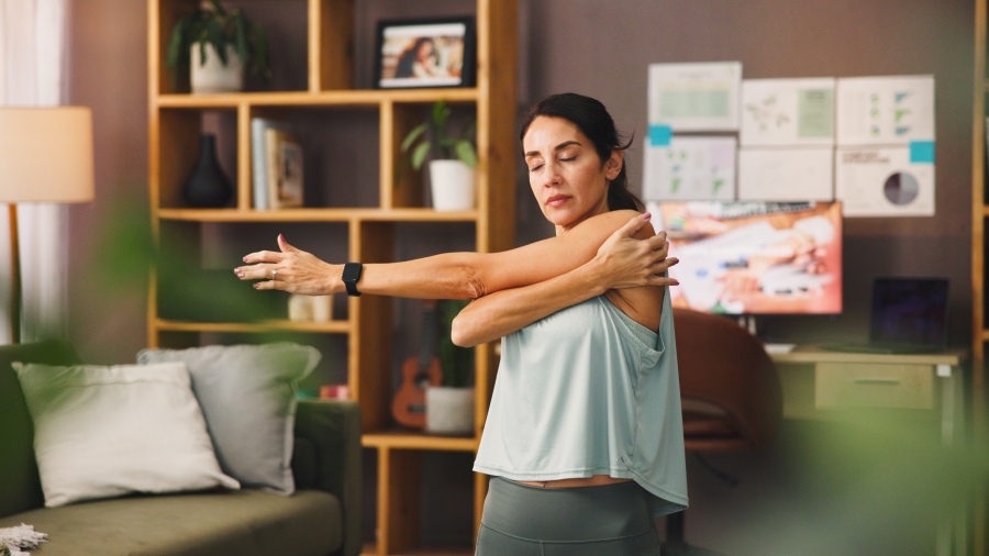Frau in Sportkleidung macht Armübung zu Hause