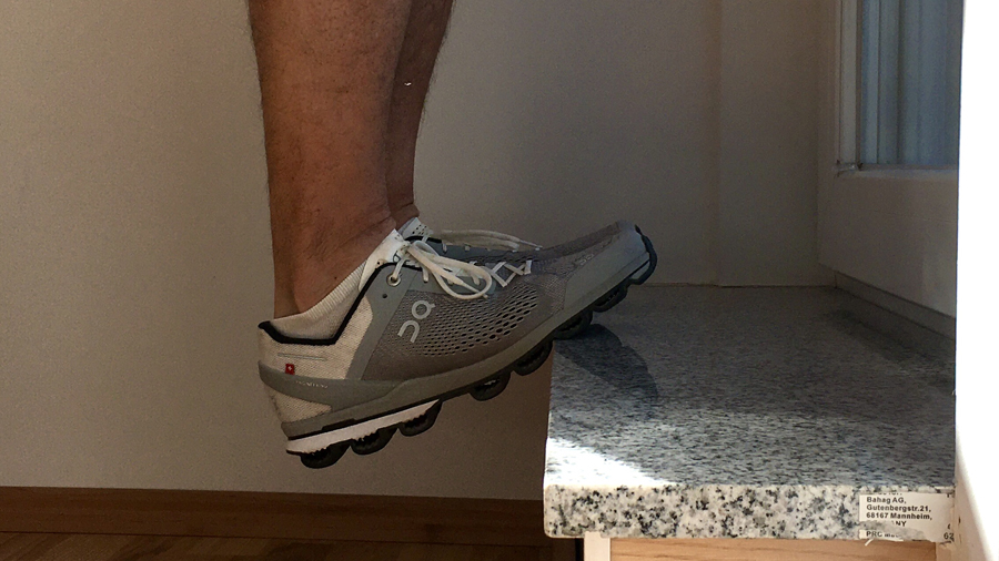 Detail: Füße auf einer Treppenstufe, Fersen nach unten