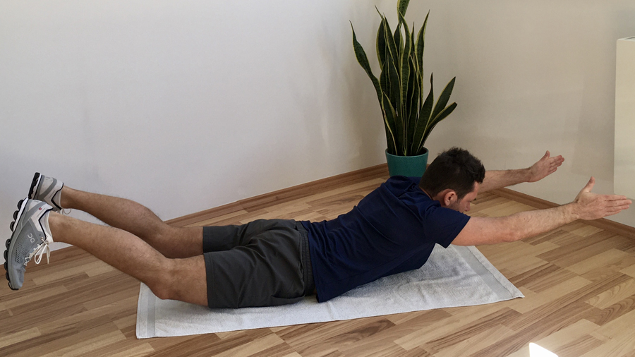 Mann, Bauchlage, Arme und Beine nach oben gestreckt