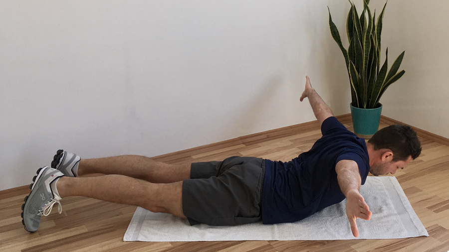 Mann hebt ausgestreckte Arme, Bauchlage