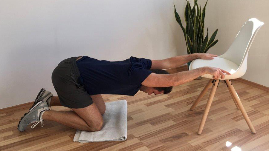 Mann, Dehnung Rücken, auf Stuhlfläche