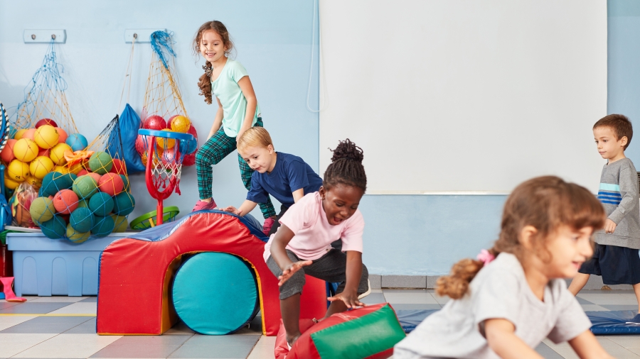 Mehrere Kinder spielen mit bunten Turngeräten