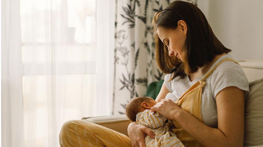 Junge Mutter stillt ihr Säugling