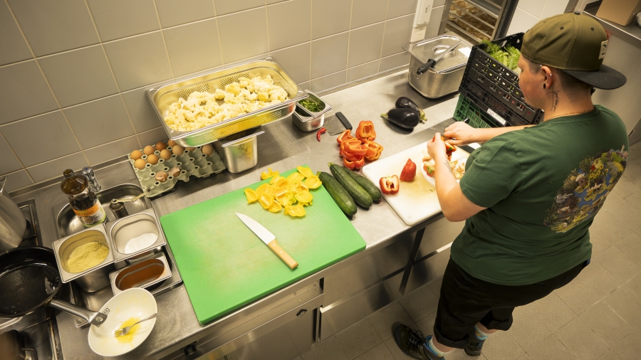 Köchin bereitet Gemüse in einer Großküche vor