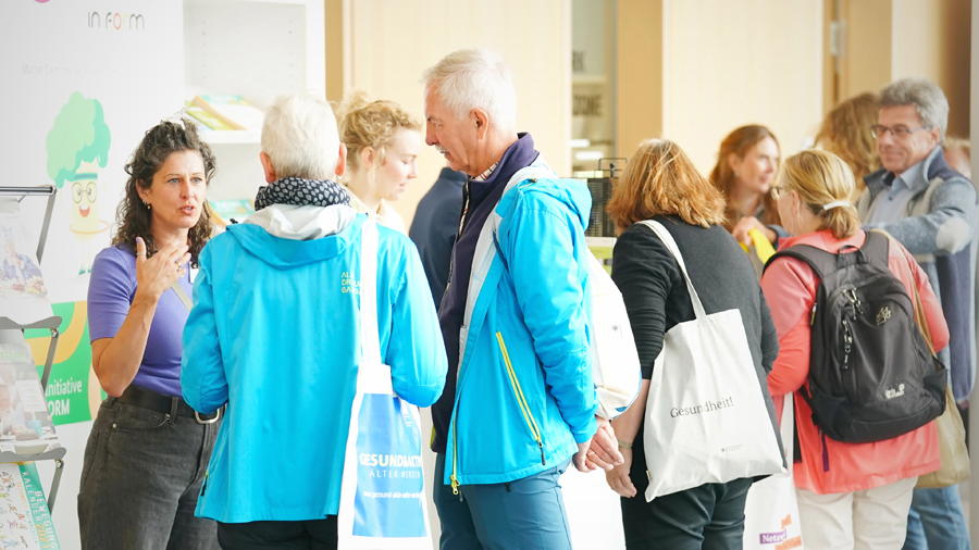 Mehrere Personen an einem Messetand im Gespräch