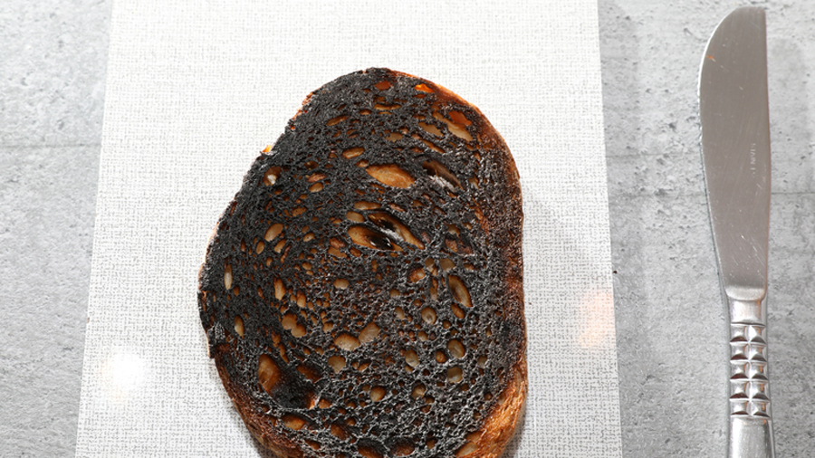 Verbrannte Brotscheibe, daneben ein Messer