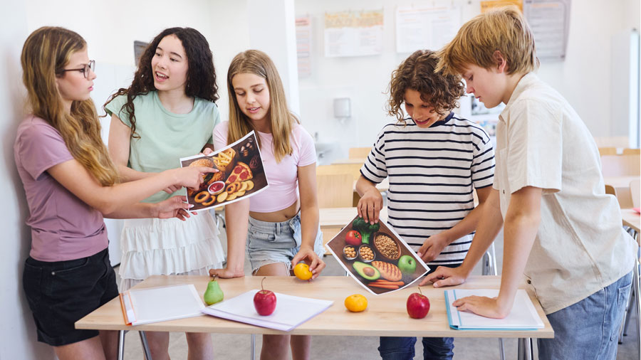 Schüler SekundarstufeI diskutieren über zwei Plaktaten mit Lebenemsittel