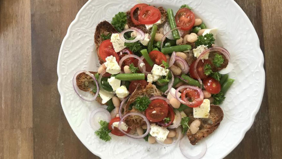 Weißer Teller von oben fotografiert mit 1 Portion Brotsalat mit zweierlei Bohnen