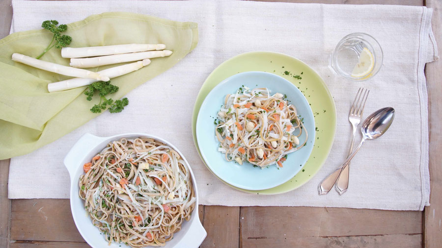 2 Schalen Spargel-Pasta mit Lachsforelle serviert und mit frischen Spargel dekoriert.