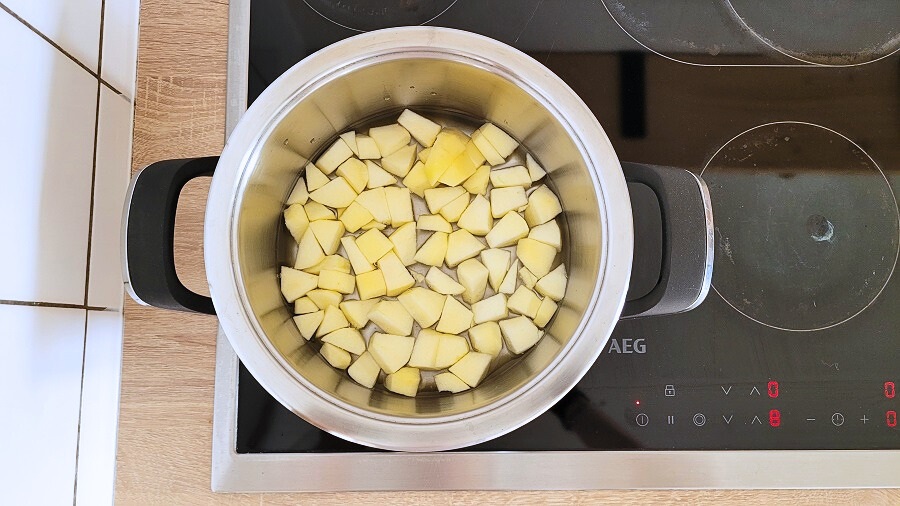 Apfelstücke in einem Topf mit Wasser.