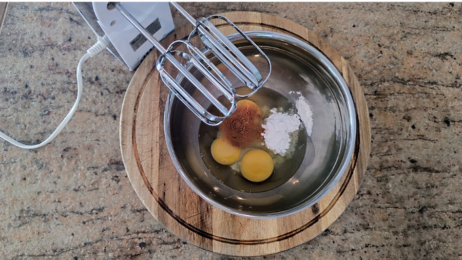 Eier, Zucker und Gewürze werden mit dem Handrührgerät geschlagen.