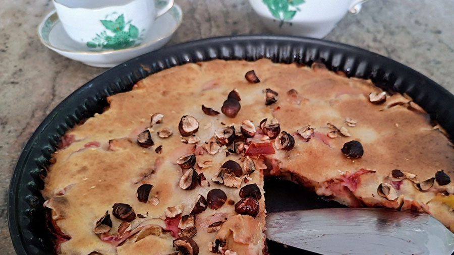 Fertiger und angeschnittener Pflaumen-Clafoutis in der Backform.