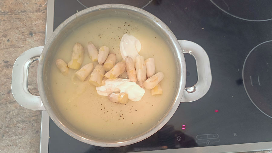 Pürierte Suppe mit Spargelspitzen und Schmand abschmecken