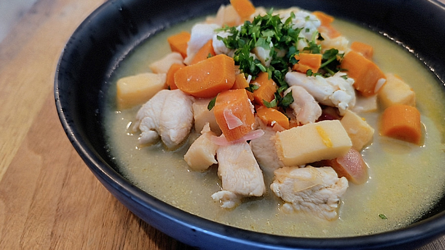 Fertiges Gericht portioniert in einem schwarzen tiefen Teller. Dekoriert mit Petersilie.