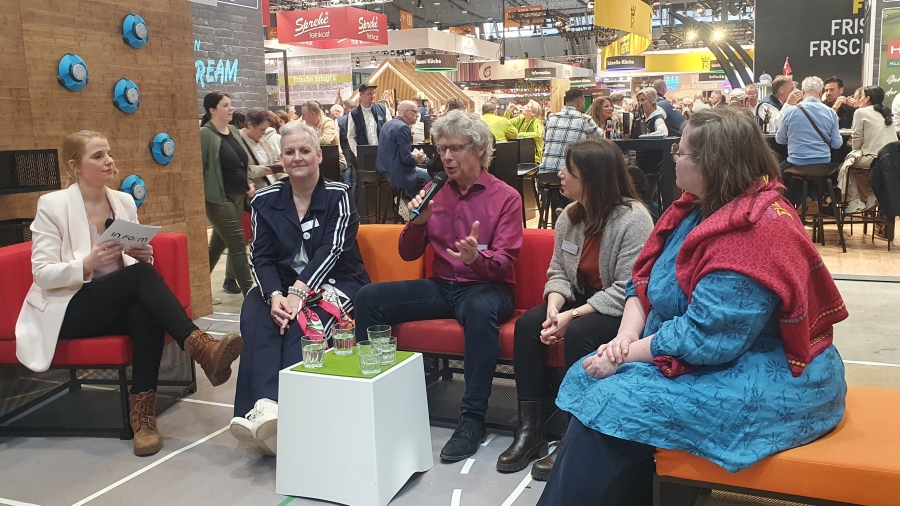 5 Personen diskutieren aufe einem Messestand