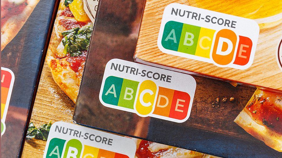 Nutri-Score-Abbildungen auf drei gestapelten Pizzapackungen (Ausschnitt)