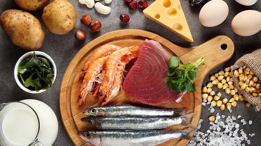 Gedeckter Tisch mit jodhaltigen Lebensmitteln wie Fisch, Milch und Salz