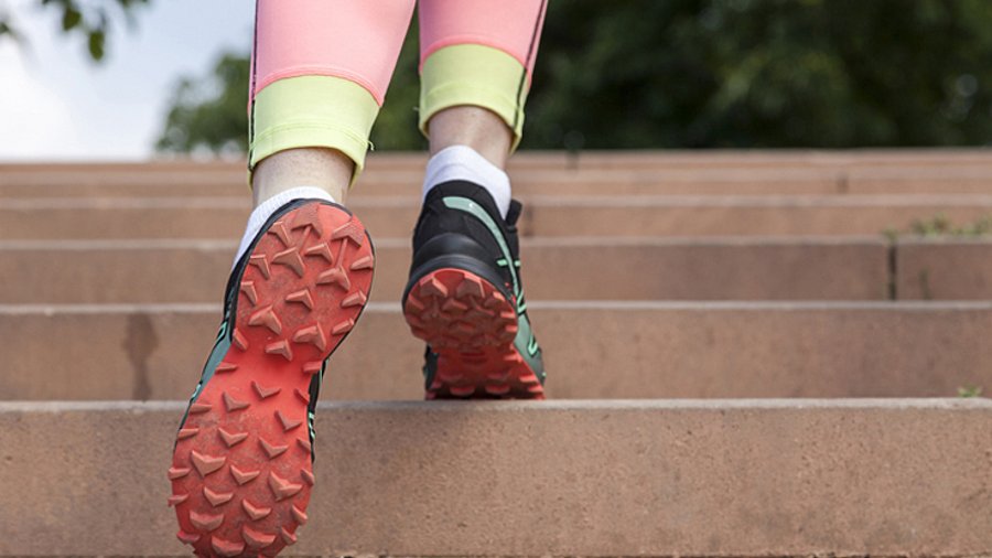 Füße mit Sportschuhen, die eine Treppe hoch laufen