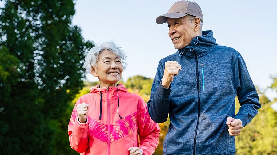 Eine ältere Frau und ein älterer Mann joggen gemeinsam.