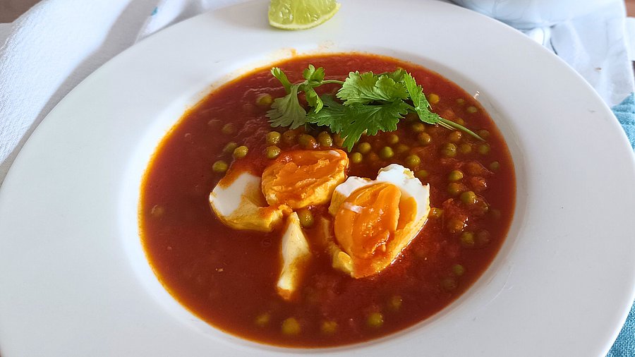 Ein Teller fertiges Eier-Erbsen-Curry.