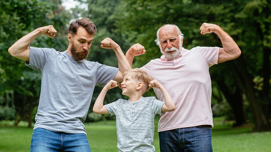 Junger Mnn, Junge und älterer Mann gemeinsam auf einer Wiese