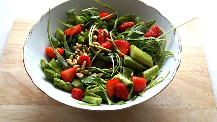 Eine weiße Salatbowl mit Spargel-Erdbeer-Salat.