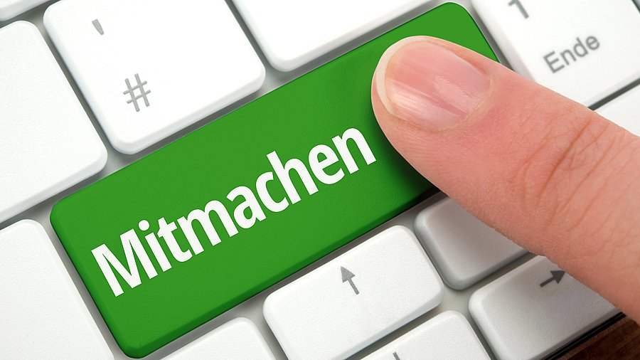 Finger tippt auf einen Button "Mitmachen" auf einer Tastatur