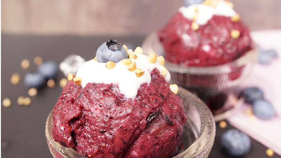 2 Kugeln Nicecream mit Heidelbeeren garniert.